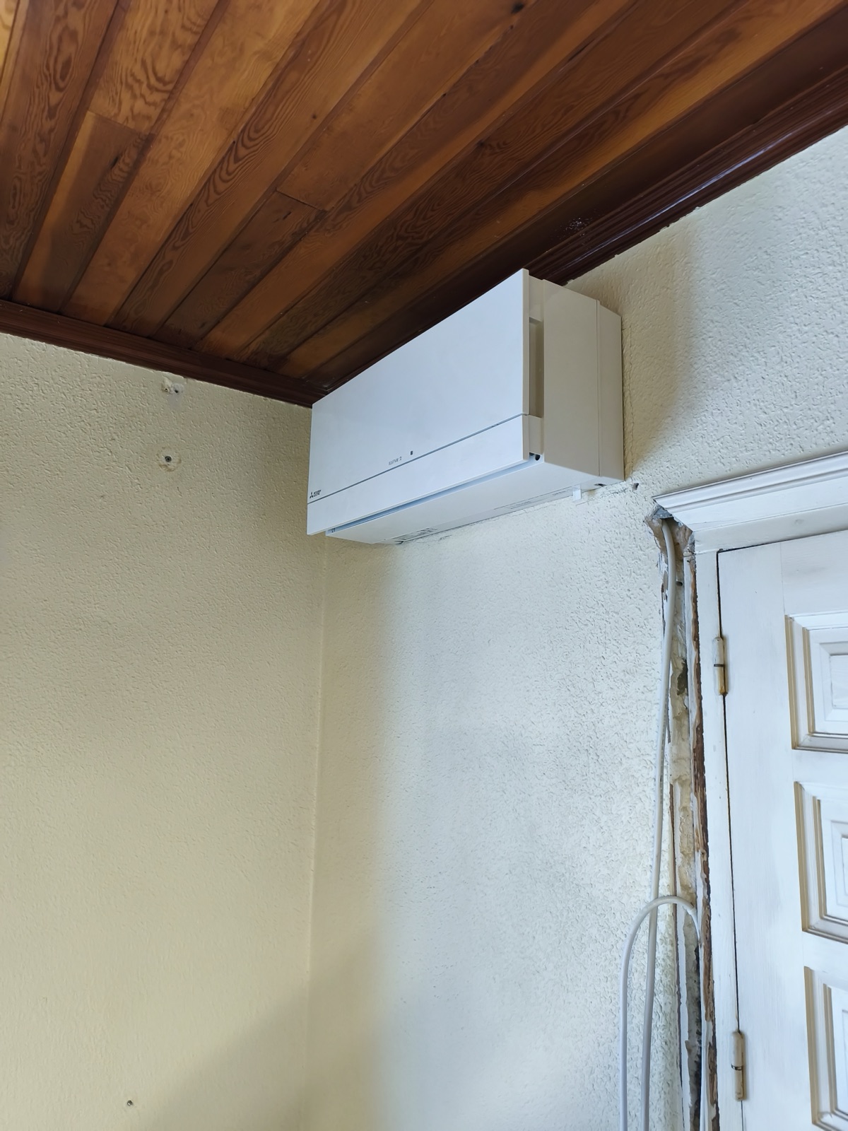 Installed split system on wall with wooden ceiling