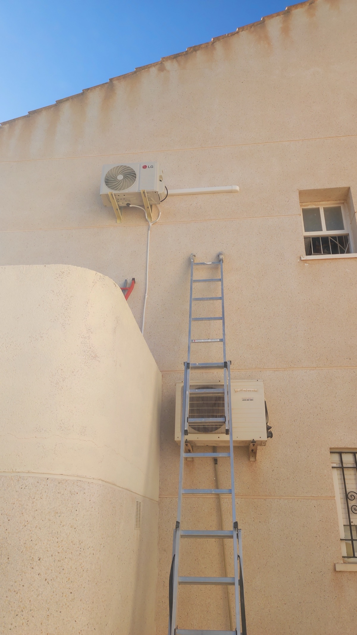 Installation of two outdoor units on facade from ladder